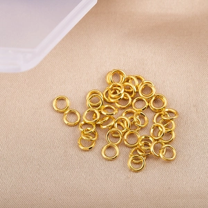 Gros plan d'anneaux ouverts dorés brillants sur soie pour la création de bijoux DIY