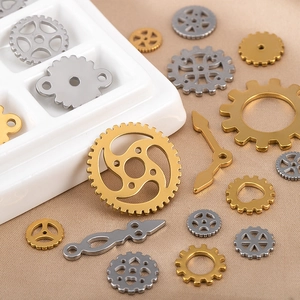 Steampunk style metal gears and clock hands for DIY jewelry making on a fabric background