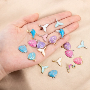 Detalle de dijes marinos esmaltados con perlas y strass para bisutería hecha a mano