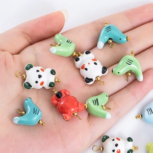 Mini pendentifs animaux en céramique dans la main montrant la taille pour bijoux artisanaux