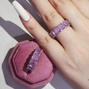 Close-up of eternity band with emerald-cut pink zircon in an octagon velvet jewelry box