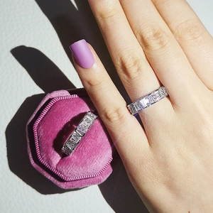 Detail of silver rings with rectangular cubic zirconia on a pink velvet box