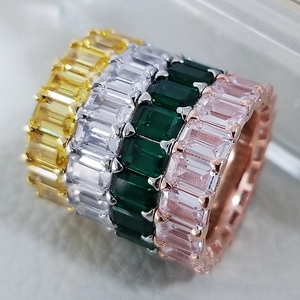 Stack of four geometric zircon rings with emerald-cut stones in yellow, green, pink, and clear