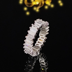 Makroaufnahme eines silbernen Eternity-Rings mit Zirkonia-Steinen auf schwarzer Oberfläche