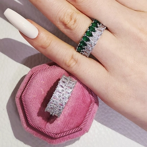 Anello a doppia fila con smeraldi e zirconi a goccia in una scatola di velluto rosa