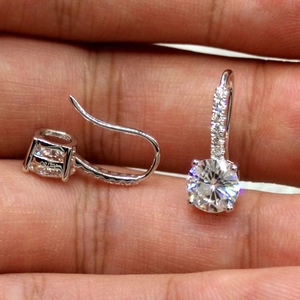 Close-up of Au750 hallmark on 18K gold drop earrings with round zircon stones