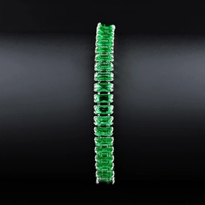 Detailed view of emerald cut green crystal tennis bracelet with silver setting