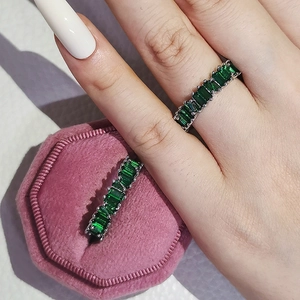 Detail von Eternity-Ringen mit smaragdgeschliffenen grünen Steinen in Silberfassung