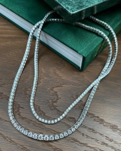 Macro shot of 4mm and 5mm zircon tennis necklaces with gradient stone sizes on wood