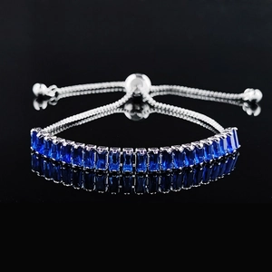 Adjustable silver bracelet featuring rectangular-cut deep blue gemstones on black background