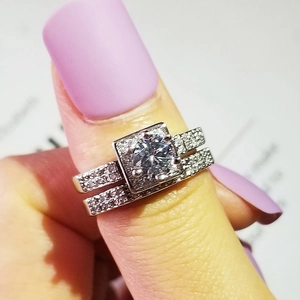 Primer plano de un lujoso anillo plateado de doble banda con un gran diamante de talla brillante