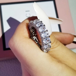 Macro shot of silver band ring with oval-cut 3A zircons in a multi-stone pavé setting