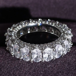 Eternity ring featuring oval-cut 3A zircons in a full-circle setting on purple velvet