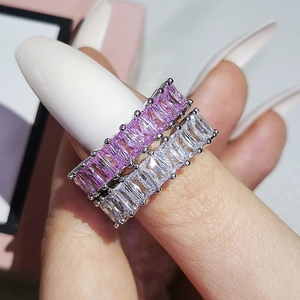 Macro view of stacked eternity rings with baguette-cut pink and white cubic zirconia