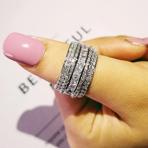 Macro view of wide silver ring with princess-cut cubic zirconia and multi-layer pave setting