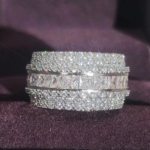 Elegant wide band ring featuring square cut cubic zirconia with shimmering pave setting