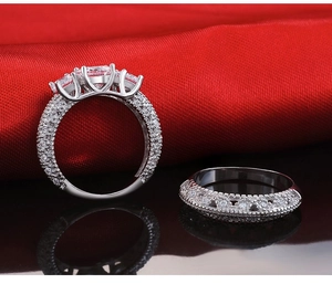 Detalle del juego de anillos de boda de plata con piedras sobre seda roja