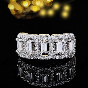 Luxury silver-tone ring with emerald-cut stones and pave zircons on black background