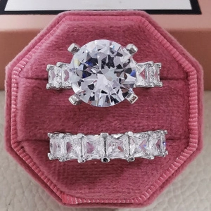 Détail des bagues empilables en zircon cœur dans une boîte à bijoux en velours rose