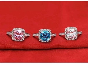Detailed view of square-cut pink, blue, and white gem rings with pavé diamond bands