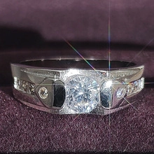 Gros plan d'une bague large argentée avec pierre en zircon sur velours violet
