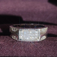 Gros plan d'une bague large pour homme avec zircons pavés sur fond de velours violet