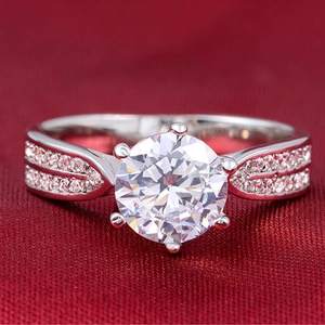 Macro-opname van zilveren ring met zes klauwen en ronde zirkonia op rood fluweel