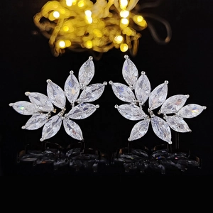 Sparkling marquise cut leaf stud earrings with silver base on a black reflective surface