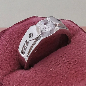 Bague pour homme en argent avec pierre centrale ronde dans un écrin de velours rouge