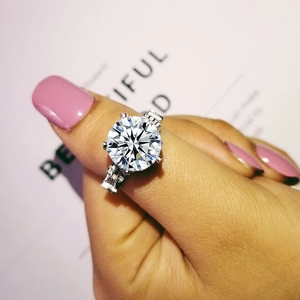 Macro shot of a luxury round brilliant cut engagement ring with six-prong setting on a hand