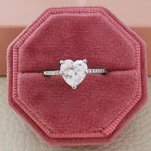Macro view of heart-cut zircon engagement ring nestled in a pink velvet jewelry box