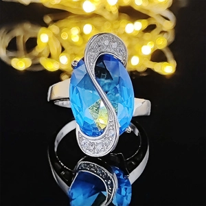Anello in argento con gemma blu ovale e intarsio a forma di S con piccoli zirconi