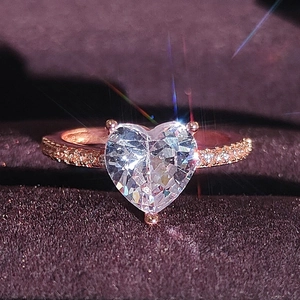 Macro shot of heart-shaped zircon ring with rose gold band and pavé diamonds on velvet