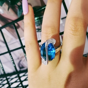 Elegante anello in argento con grande pietra blu ovale e brillanti diamanti laterali