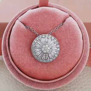 Detailed view of silver micro-pave zircon sunburst pendant in pink velvet jewelry box