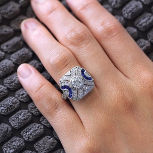 Macro detail of vintage style ring with sapphire accents and pavé-set zircons on hand