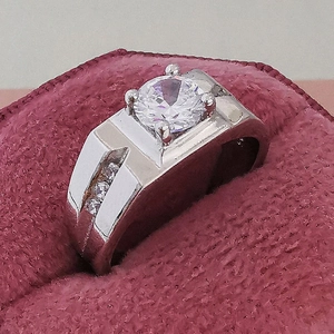 Anello da uomo in argento con pietra centrale rotonda in una scatola di velluto rosso