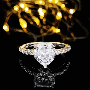 Elegant heart-shaped zircon engagement ring with pavé setting and bokeh background