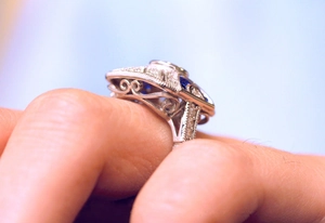 Detailed side view of vintage silver ring with blue zircon and hollow filigree design