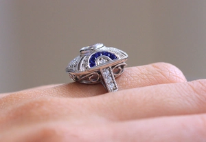 Macro shot of vintage hollow ring with blue sapphire and white zircon gemstones