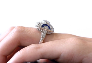 Macro shot of an Art Deco silver ring with deep blue sapphire and micro-pave diamonds