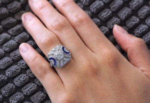 Close-up of vintage Art Deco ring with blue sapphire accents and center zircon