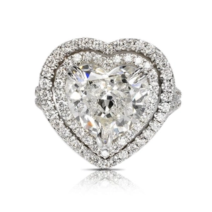 Luxuriöser herzförmiger Diamantring mit doppeltem Halo und Pavé auf weißem Hintergrund