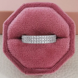 Anillo de eternidad de lujo con varias filas de pavé en un joyero de terciopelo rosa