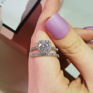Close-up of luxury two-piece silver ring set with halo round zircon on hand