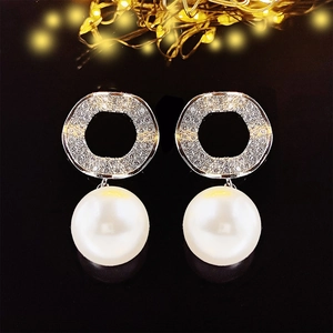 Elegant silver pearl drop earrings with sparkling round studs on a black background