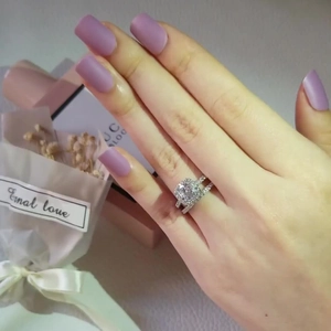 Silver square cut halo engagement ring set worn on hand with floral gift box