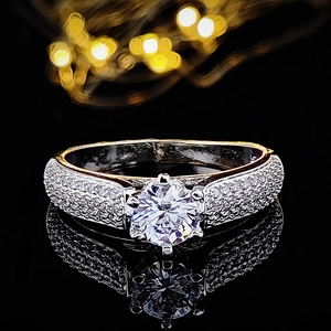 Toma macro de un anillo de diamante de seis garras con banda de plata pavé y reflejo nítido