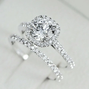 Luxury halo bridal ring set featuring a round center stone and pave diamond bands