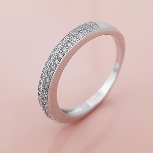 Elegant triple row pave set zircon ring in polished silver finish on warm background